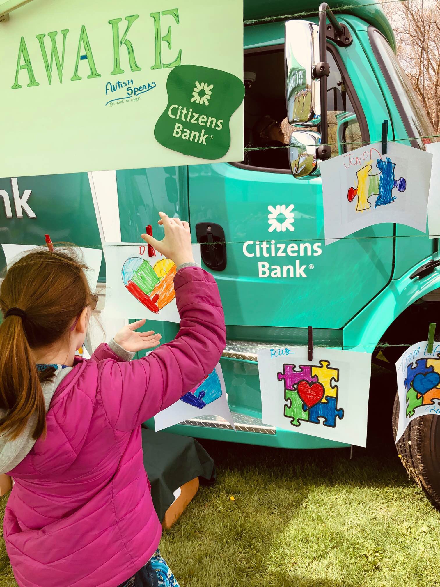 Woman at citizens truck with autism puzzle logo