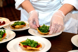 food service worker handling food with gloves on